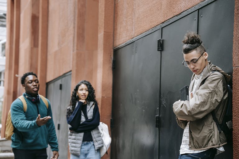 Group of diverse teenagers having a serious discussion in an urban outdoor setting.